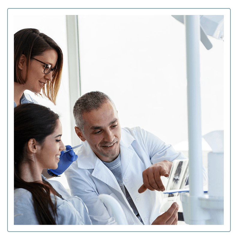 dentists shows their patient her dental charts