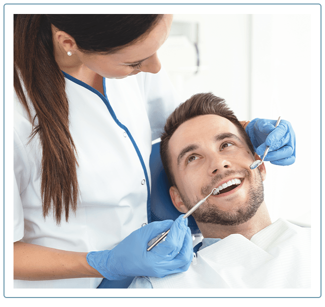 Dentist cleaning a man's teeth