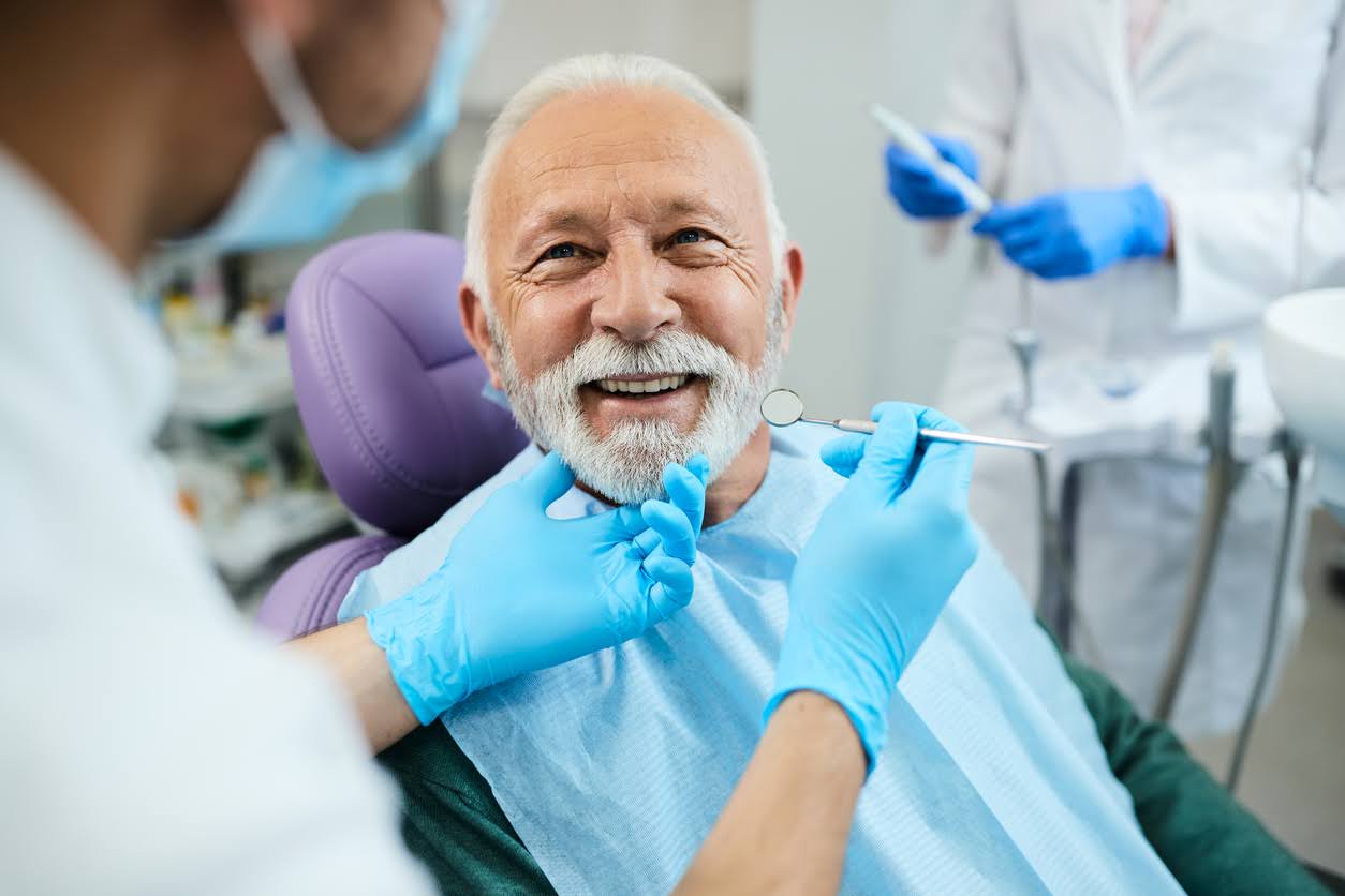 Happy senior man having dental treatment at dentist's office