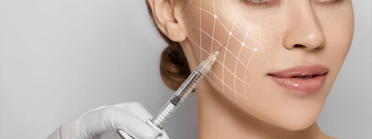 A woman looks at the camera while a gloved hand pushes a syringe into her cheek where a grid has been marked.