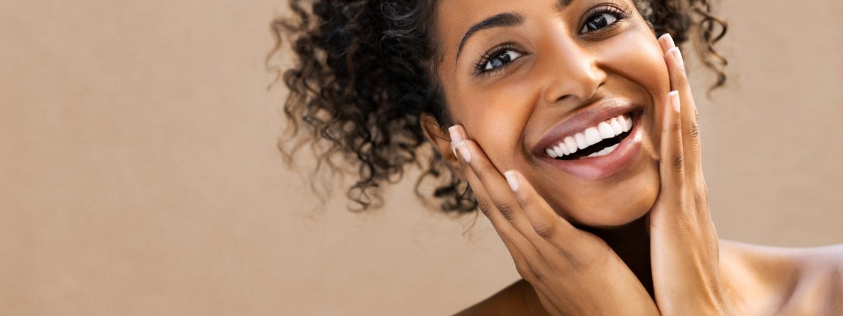 Surprised beautiful black woman A patient with a bright, sparkly smile is thrilled after a comfortable dental spa treatment in Birmingham, AL.